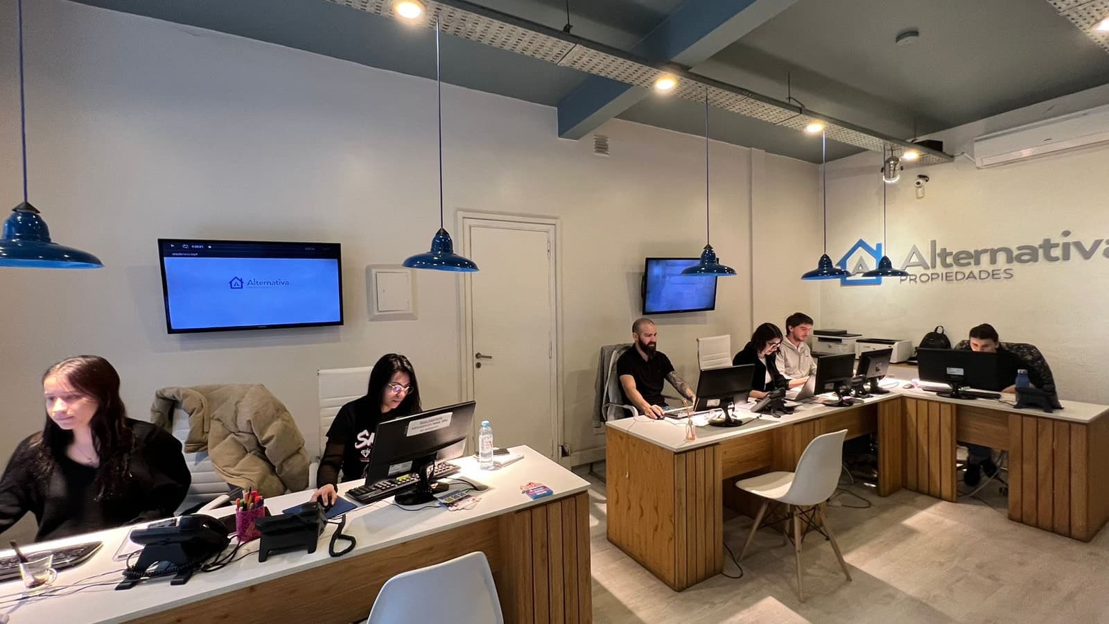 Equipo de Alternativa Propiedades atendiendo en la oficina de Palermo